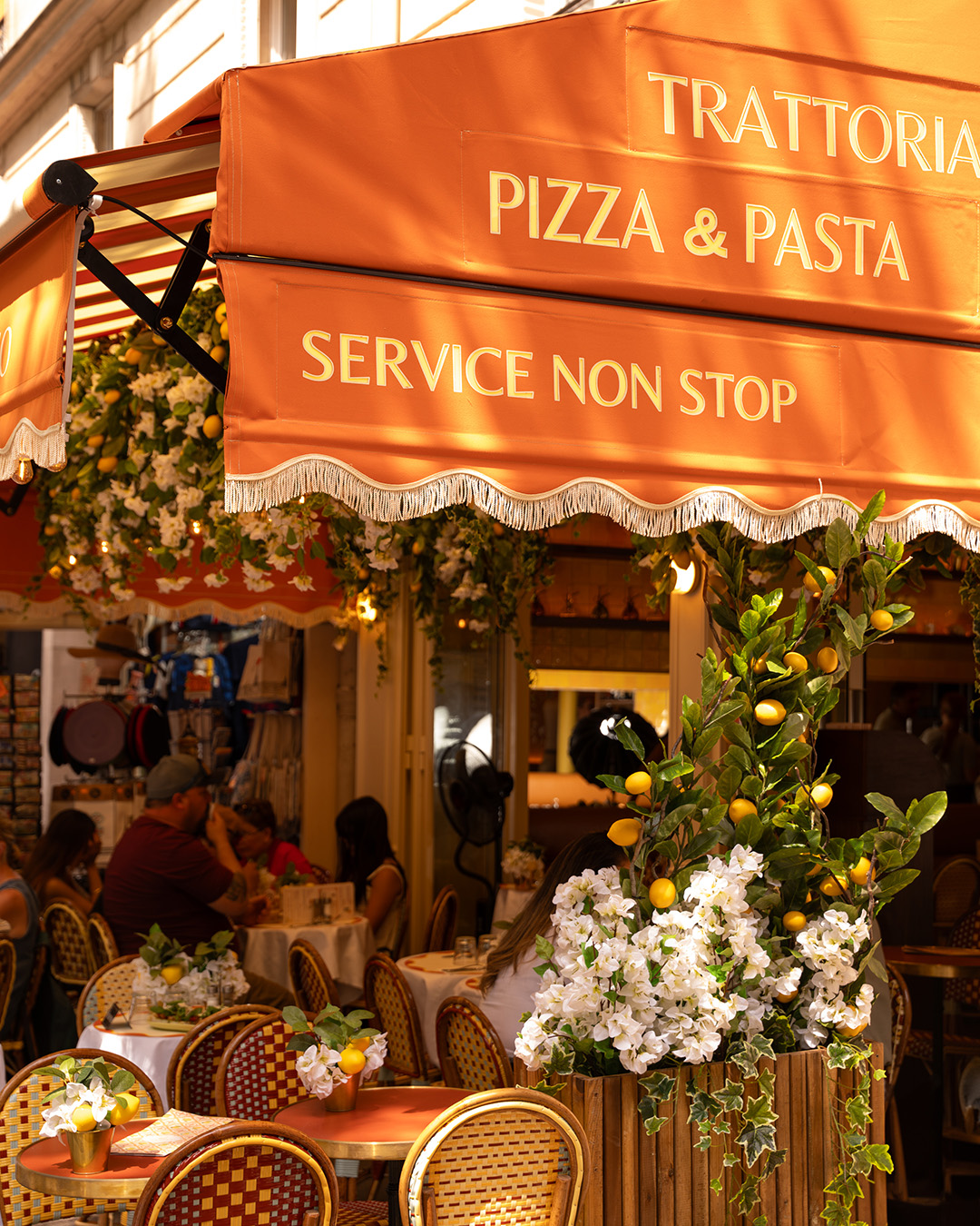 La terrasse fleurie de Casa Nina sous son store orange